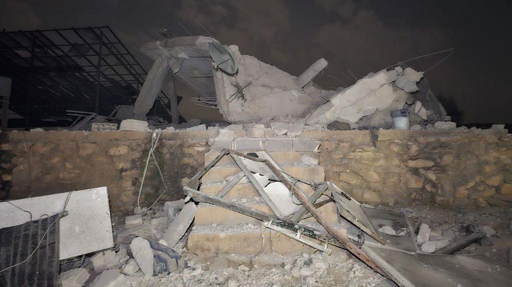Rubble sits atop a small brick wall