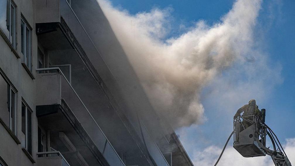 Firefighters at the scene of an apartment block fire in Antwerp