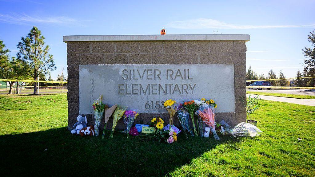 Flowers lay against the entrance sign of Silver Rail Elementary School on October 16, 2026 in Bend, Oregon.