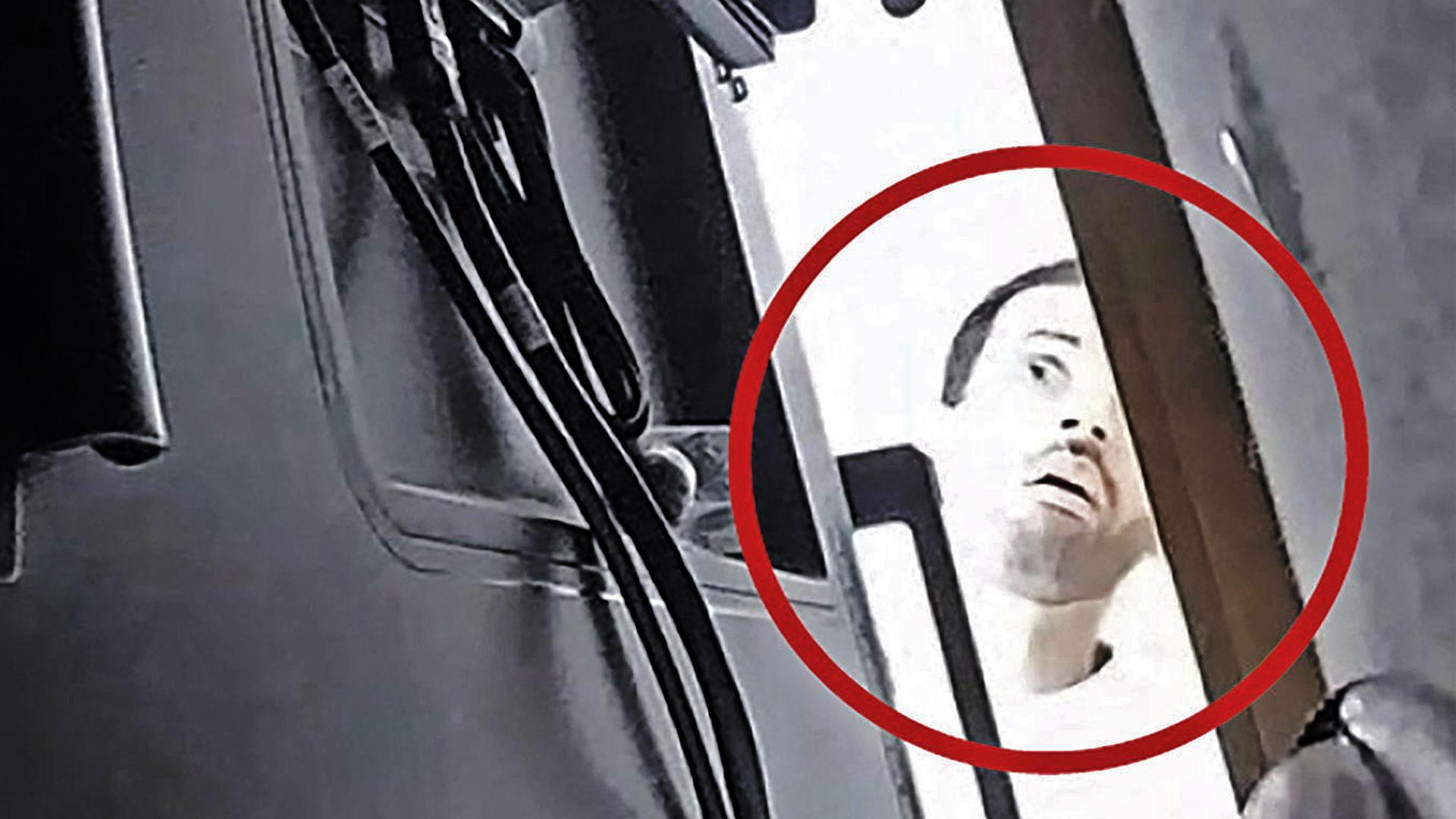 CCTV image of a man in a conference room holding a device
